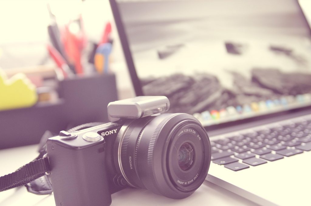 Persoon die met AI-tools een digitaal fotoarchief organiseert op een laptop