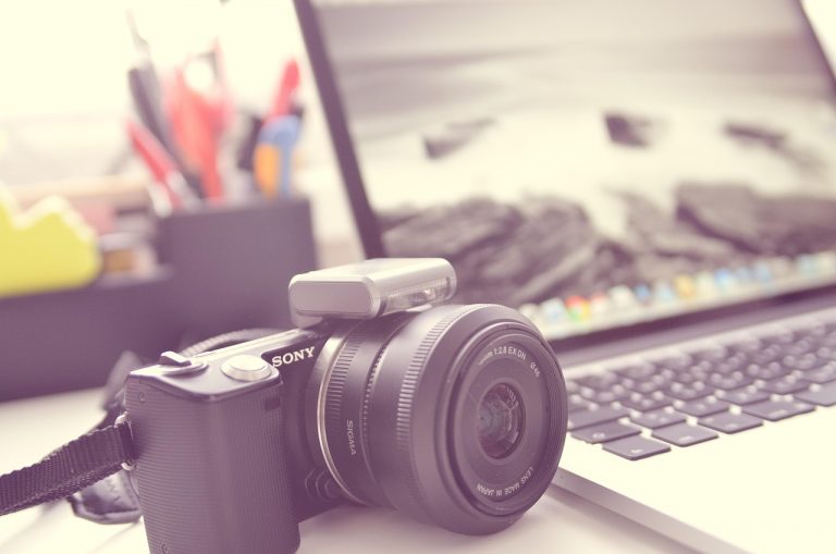 Persoon die met AI-tools een digitaal fotoarchief organiseert op een laptop