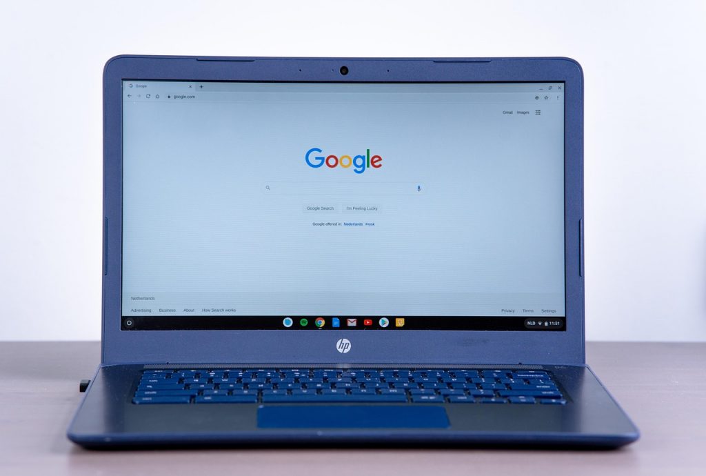 Persoon die Google zoekresultaten bekijkt op laptop met een AI-overzicht bovenaan de pagina