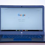 Persoon die Google zoekresultaten bekijkt op laptop met een AI-overzicht bovenaan de pagina