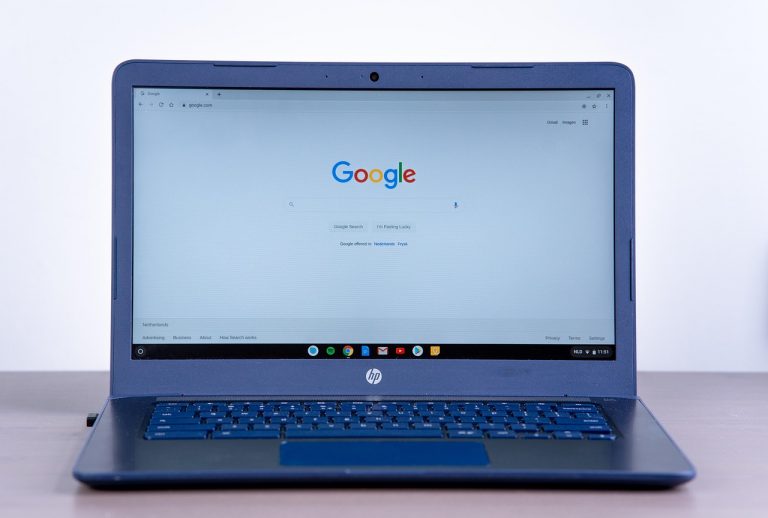 Persoon die Google zoekresultaten bekijkt op laptop met een AI-overzicht bovenaan de pagina
