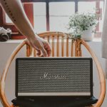 Waterbestendige Bluetooth-speaker op het strand met zonnige zomerdag op de achtergrond