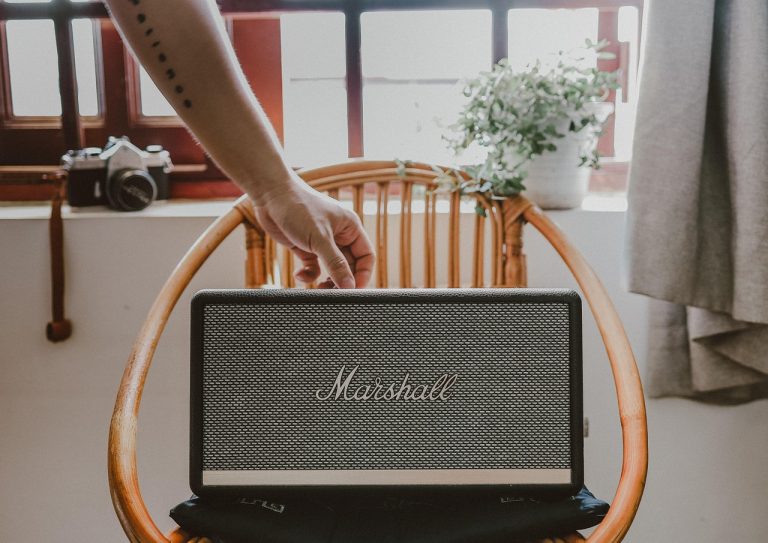 Waterbestendige Bluetooth-speaker op het strand met zonnige zomerdag op de achtergrond