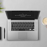 Persoon die een tweedehands laptop nauwkeurig inspecteert op schermkwaliteit en toetsenbord