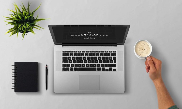 Persoon die een tweedehands laptop nauwkeurig inspecteert op schermkwaliteit en toetsenbord