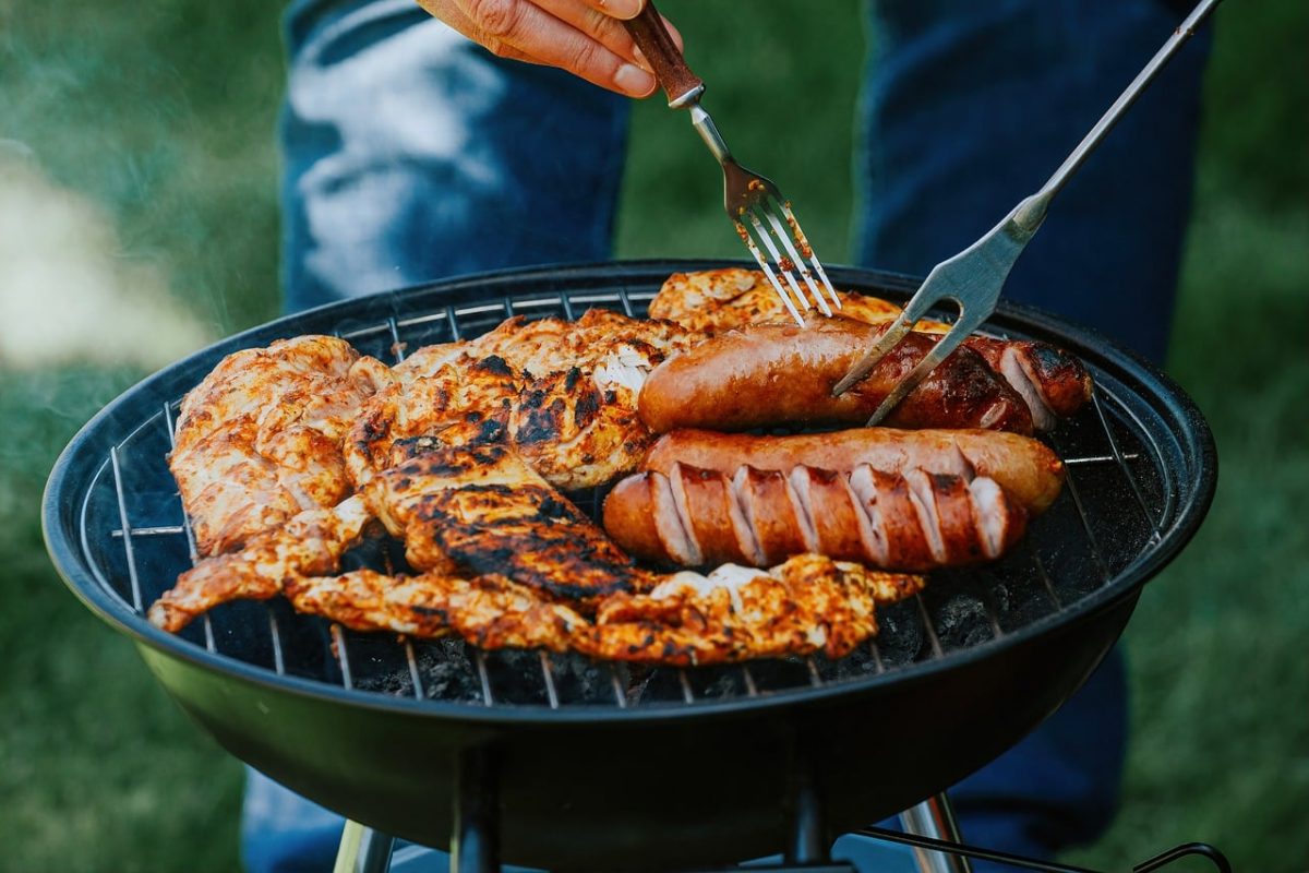 Vlees op een houtskoolbarbecue met kolen en een rooster boven direct en indirect vuur