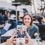 Iemand gebruikt Google Lens op een smartphone om een plant te herkennen in de tuin