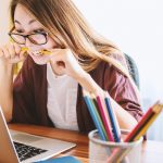 Persoon die artikelen leest op laptop terwijl een AI-tool een samenvatting toont op het scherm