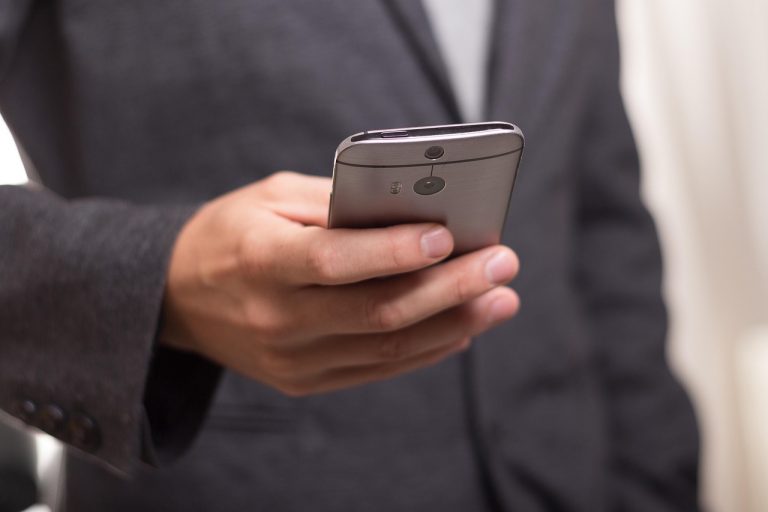 Smartphone met opslagoverzicht op het scherm, omgeven door opgeruimde digitale iconen