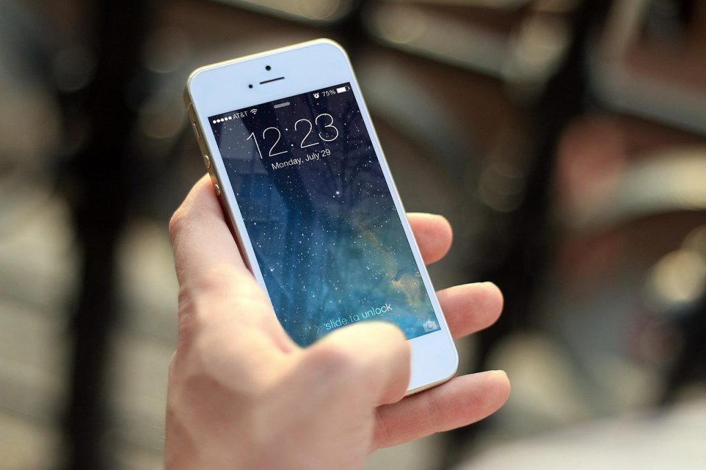 Persoon die een tweedehands smartphone inspecteert voordat hij betaalt