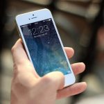 Persoon die een tweedehands smartphone inspecteert voordat hij betaalt