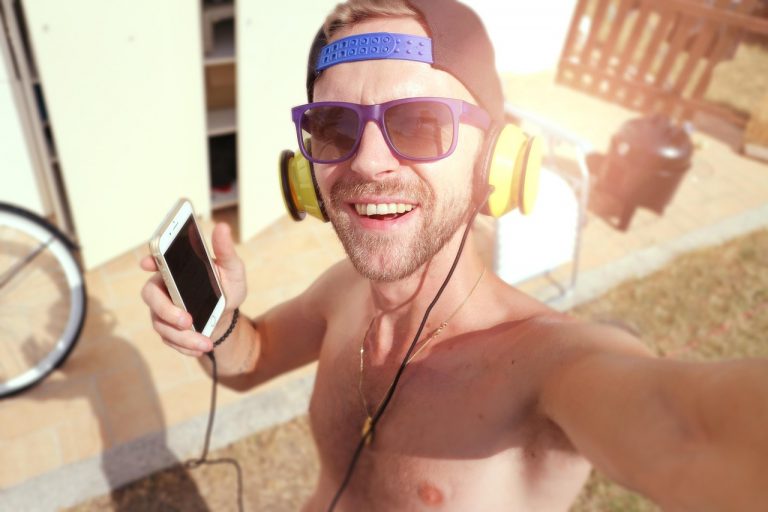 Persoon die met koptelefoon muziek luistert en een playlist samenstelt op zijn laptop