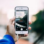 Iemand die een foto verstuurt via een berichtenapp op een smartphone