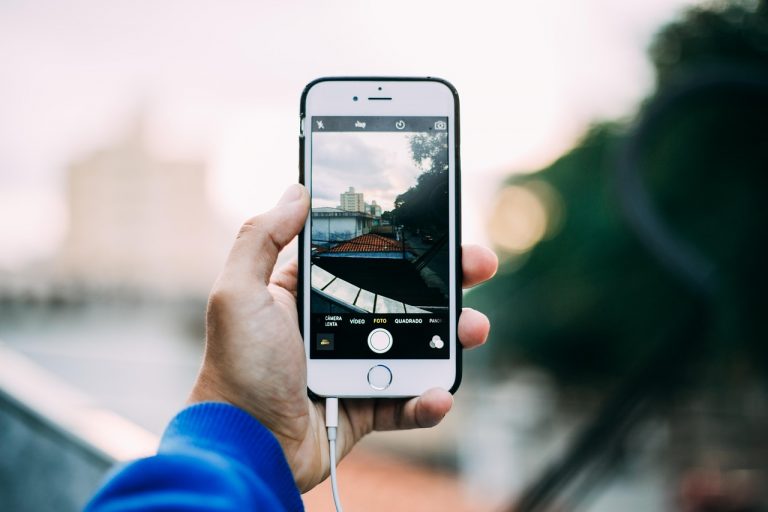 Iemand die een foto verstuurt via een berichtenapp op een smartphone