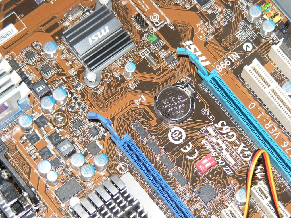 Binnenkant van een computer met moederbord, ventilatoren en kabels zichtbaar