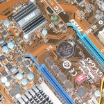 Binnenkant van een computer met moederbord, ventilatoren en kabels zichtbaar