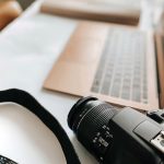 Een beschadigde laptop op een werktafel, met gereedschap ernaast klaargelegd voor reparatie