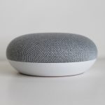 Persoon die een slimme speaker aanspreekt in de keuken voor een ochtendroutine
