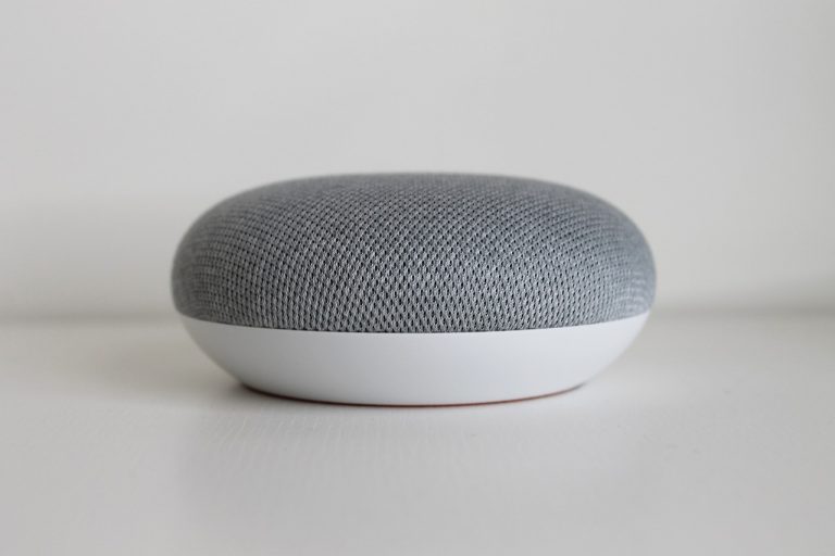 Persoon die een slimme speaker aanspreekt in de keuken voor een ochtendroutine