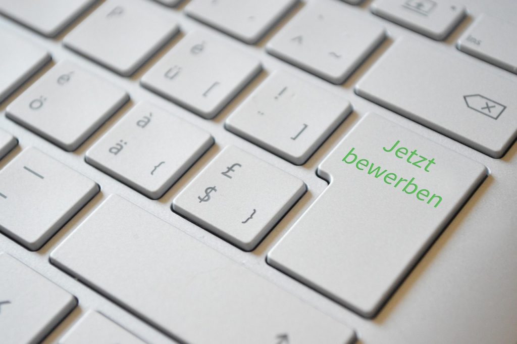 Persoon die een online sollicitatie verstuurt via een laptop