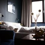Een draadloze speaker op een hotelkamertafel naast een smartphone