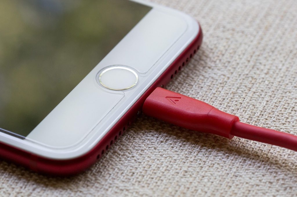 Smartphone met powerbank op een zonnig festival