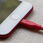Smartphone met powerbank op een zonnig festival