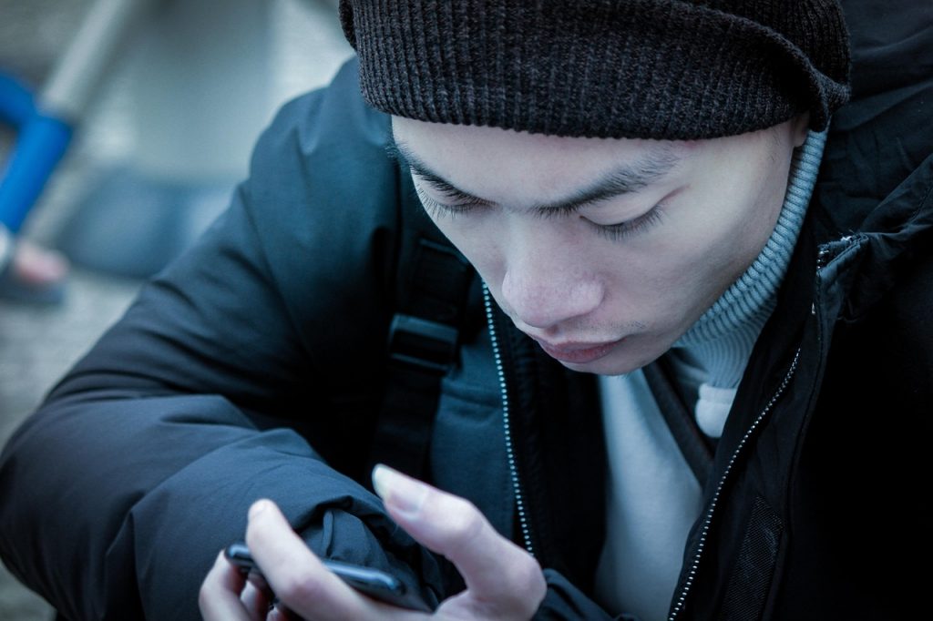 Persoon die eindeloos door de feed van een smartphone scrollt
