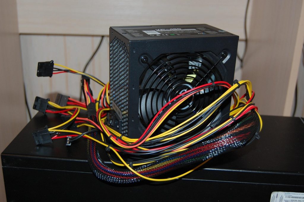 Een voedingseenheid van een desktop computer met zichtbare kabels en aansluitingen