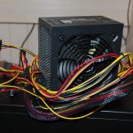 Een voedingseenheid van een desktop computer met zichtbare kabels en aansluitingen