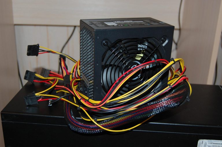 Een voedingseenheid van een desktop computer met zichtbare kabels en aansluitingen