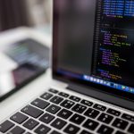 Persoon die op een laptop werkt en een WordPress-thema aanpast met behulp van een AI-code-editor