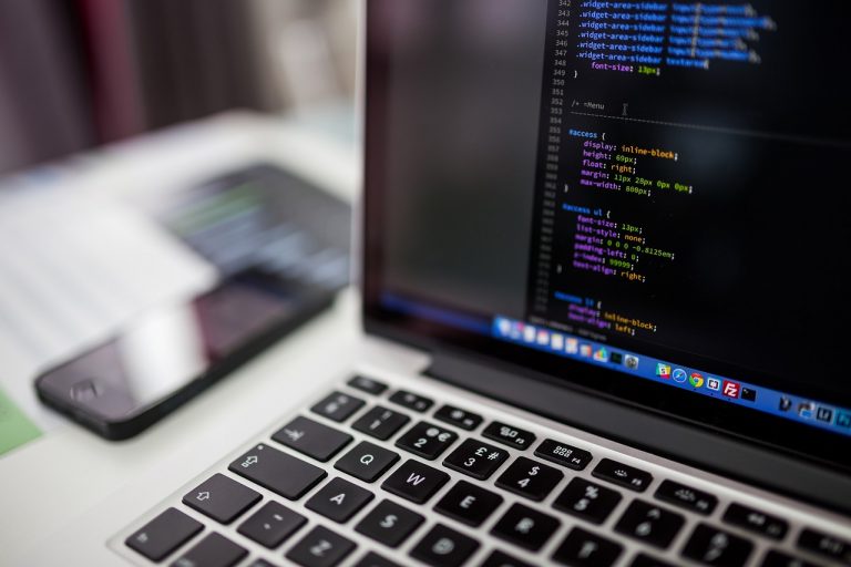 Persoon die op een laptop werkt en een WordPress-thema aanpast met behulp van een AI-code-editor