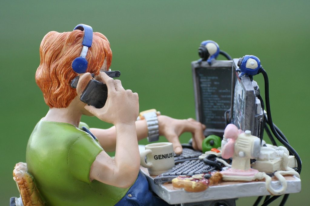 Een persoon die achter een laptop werkt en code typt in een editor