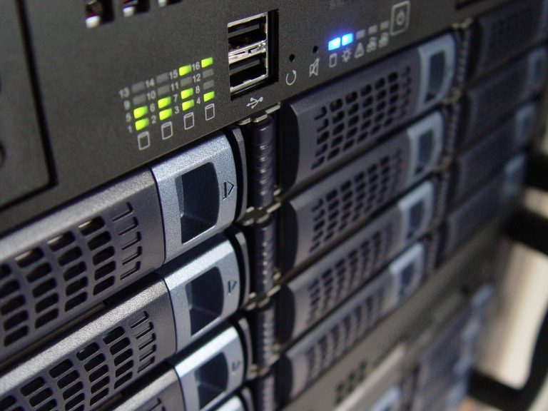 Rijen serverkabinetten in een machinehal van een groot rekencentrum met blauwe verlichting