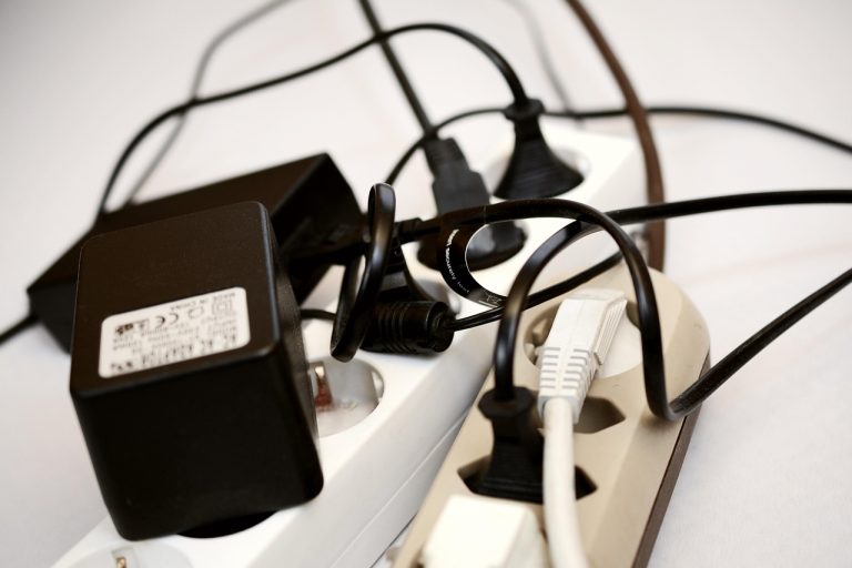 Een laptopstroomadapter met kabel en connector op een bureau