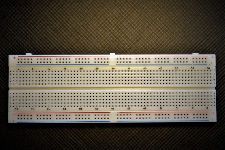Een transistor aangesloten op een breadboard met weerstanden en een LED, klaar voor een beginnerscircuit